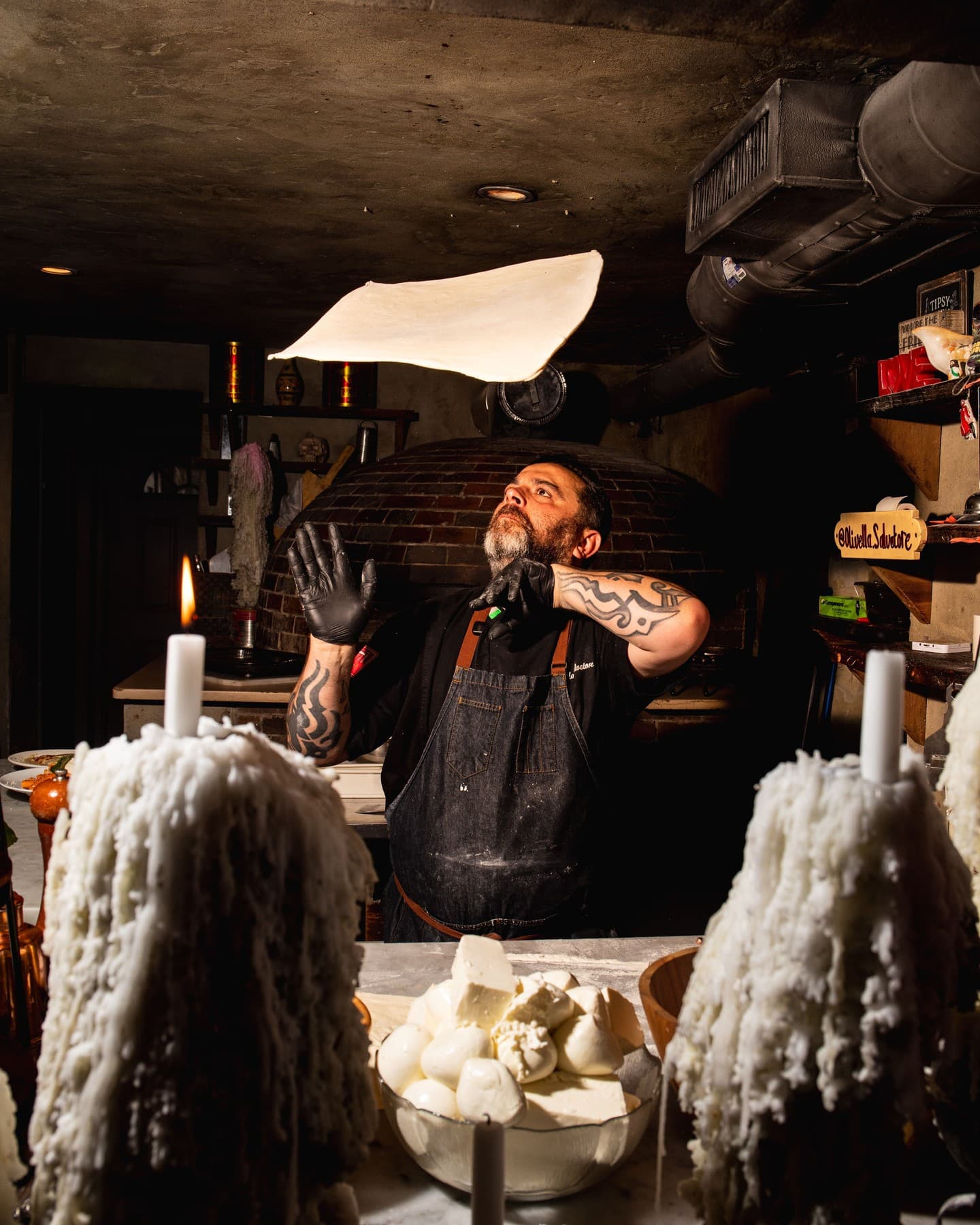 Salvatore tossing pizza dough in the air