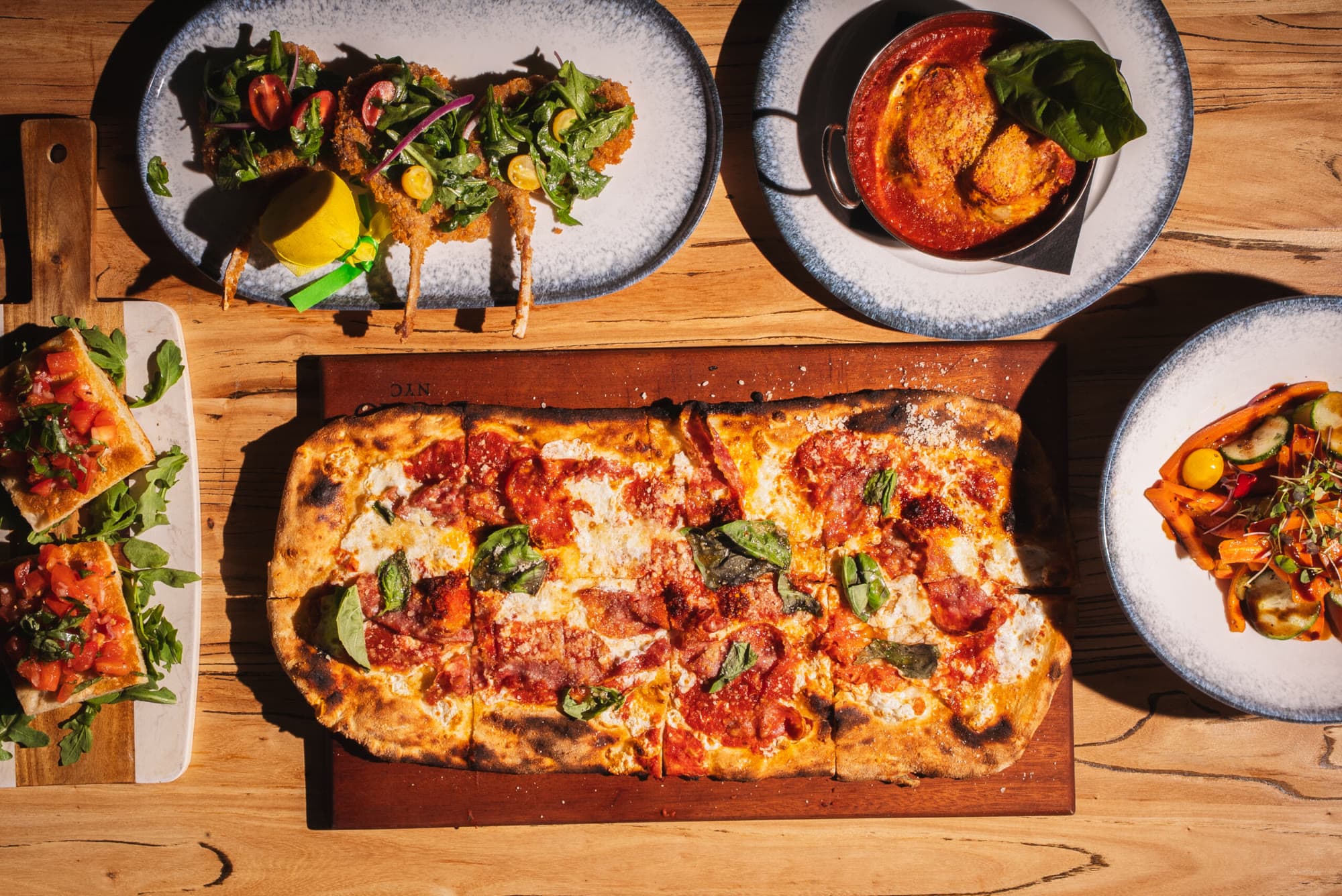 Pizzas and starters on a table at Forno d'Oro