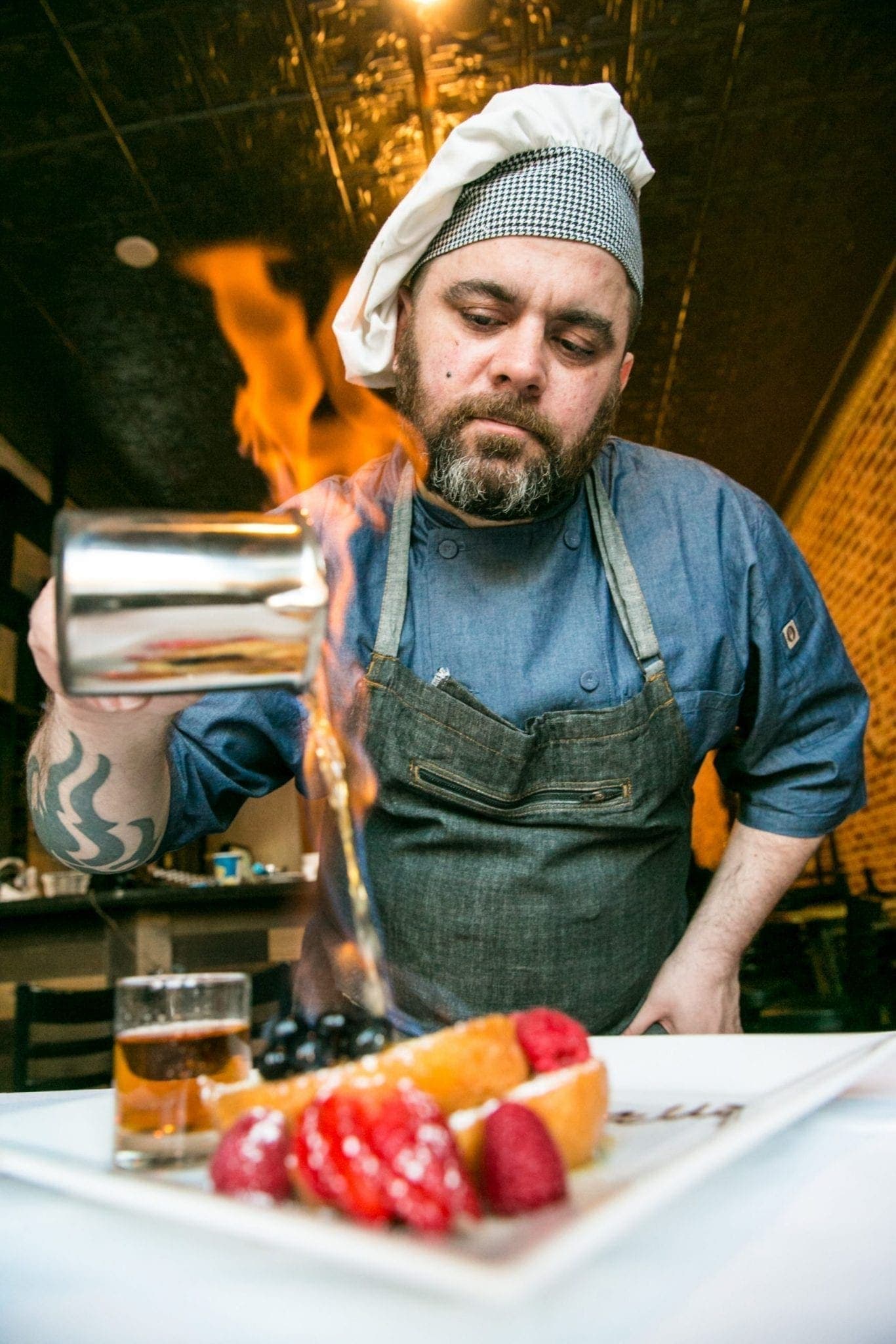 Chef Salvatore Olivella pouring a flaming sauce over a dessert