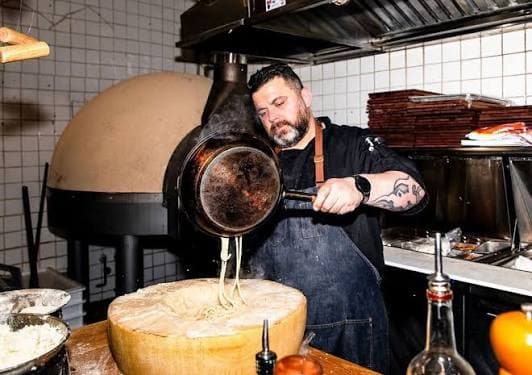 Spaghetti tossed in a wheel of Parmigiano